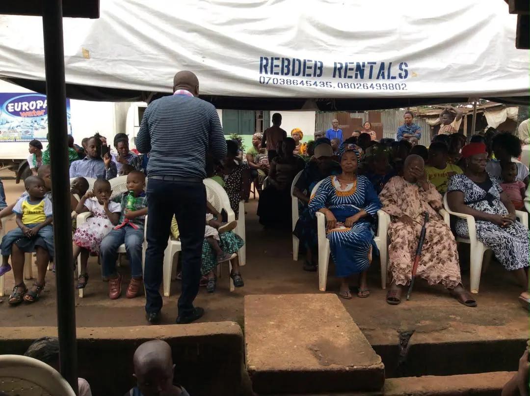 A wide view of residents seated under a canopy at a RAMES outreach.