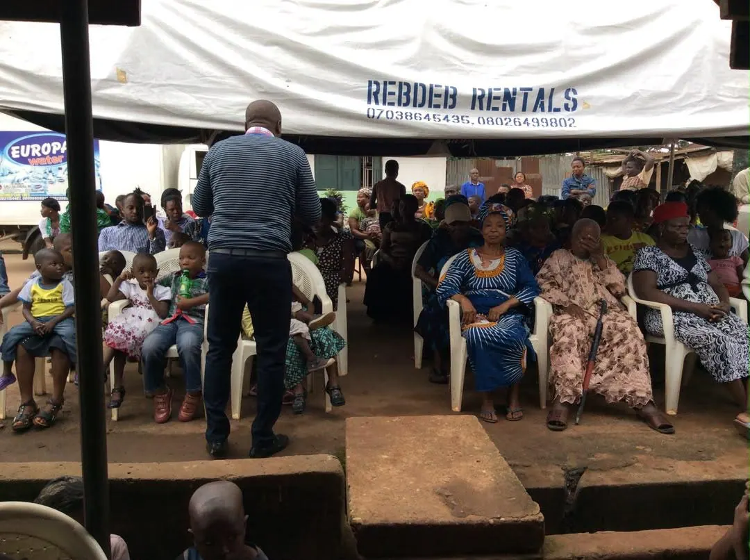 A wide view of residents seated under a canopy at a RAMES outreach.