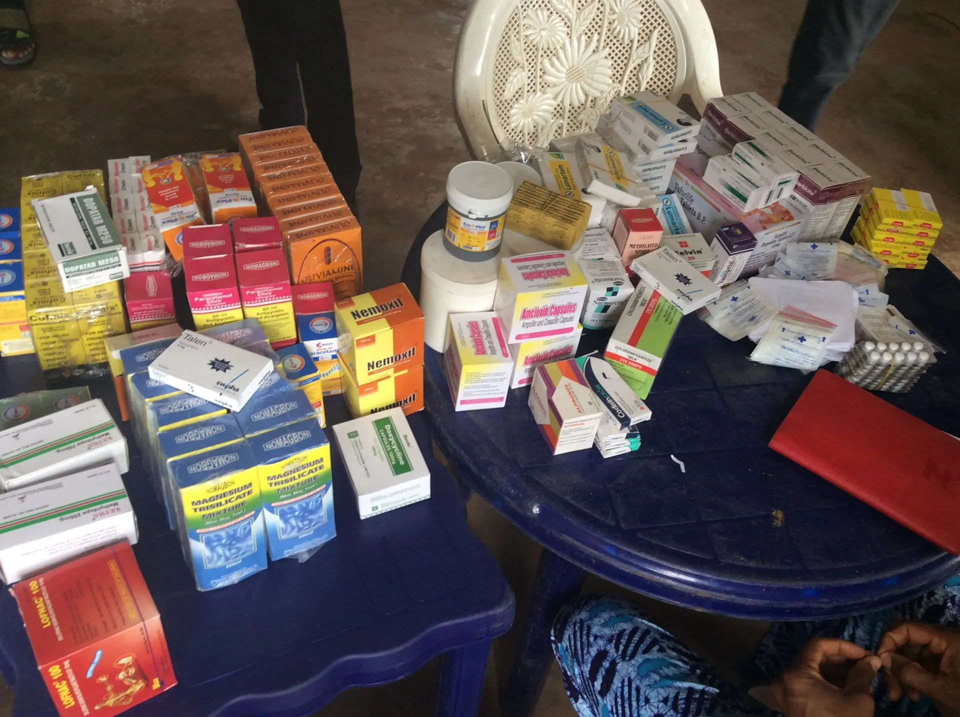 A table stacked with boxes of medicines and supplements prepared for free distribution at a medical outreach.